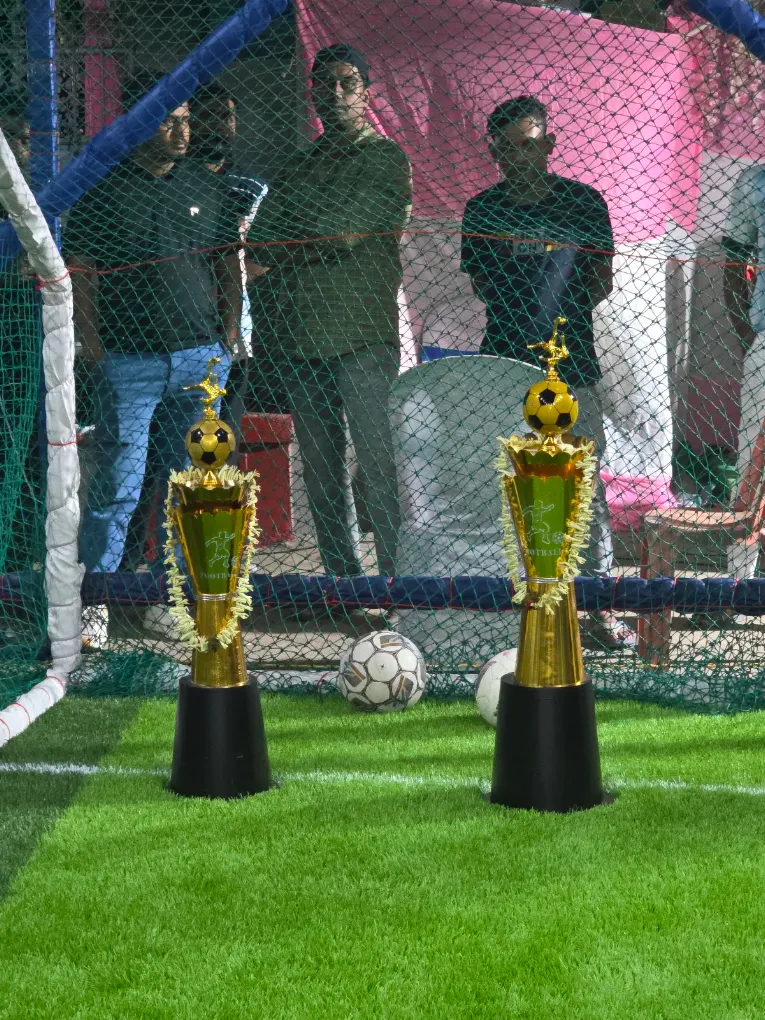 Football tournament trophies placed near the goal